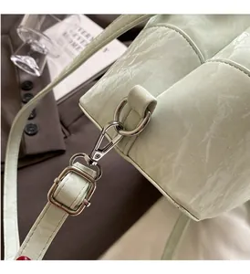 Detailed view of light green bucket bag with premium silver hardware and textured leather