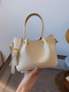 Chic cream leather bucket bag with top handle and adjustable crossbody strap