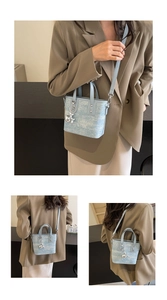 Detail view of mini light blue textured tote bag with silver rabbit charm and crossbody strap