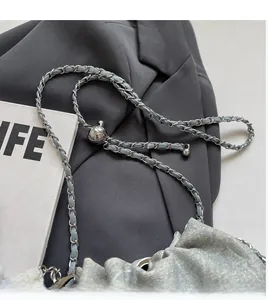 Detail of adjustable silver chain strap and monogram pattern on blue crossbody bag
