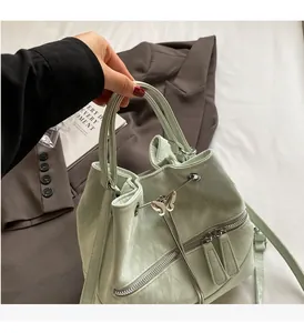 Detail of mint green textured leather bucket bag with silver butterfly and drawstring