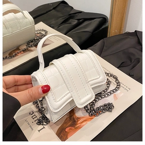 Detailed macro view of cream mini bag with stone pattern texture and chain strap