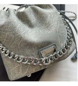 Detailed close-up of high-quality silver metal chain and canvas texture on crossbody bag