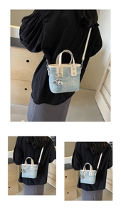 Detail of light blue denim tote with off-white handles and silver balloon dog charm