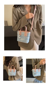 Close-up of contrast color mini bucket bag with blue denim texture and pink leather straps