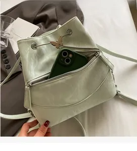 Detail view of mint green bucket bag with ruffle texture and butterfly buckle on fabric