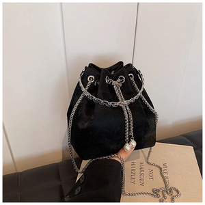 Close-up of black velvet bucket bag with silver chain and white pearl drawstring detail