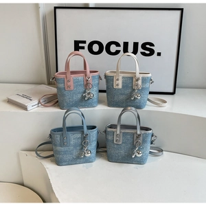 Detail of colorful mini bucket bags in denim fabric with metal charms and leather trim