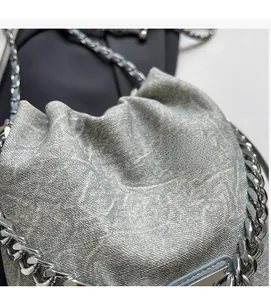 Detailed view of the textured monogram fabric and metal chain strap on the bucket bag