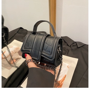 Close-up of black crocodile pattern mini square bag with metal chain and top handle