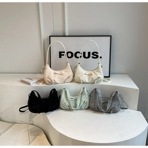 Five French style handbags with bow details in diverse colors on minimalist white steps