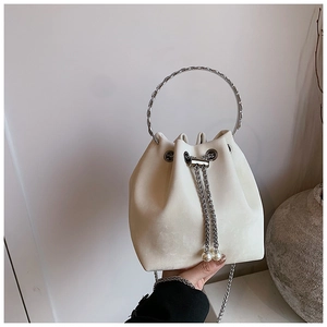 Detail of cream bucket bag with silver ring handle, drawstring and pearl accents