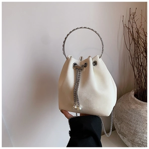 Detail of off-white bucket bag with silver metal ring handle and pearl drawstring