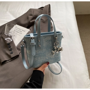 Detail of light blue glitter denim tote bag with silver balloon dog charm decoration