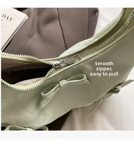 Close-up of the smooth silver zipper and green leather texture on a stylish handbag