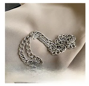 Close-up of premium silver metallic chain links on textured brown fabric detail
