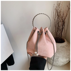 Macro detail of pink bucket bag with metal ring handle and pearl drawstring charms