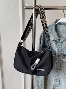 Black nylon shoulder bag with geometric strap and OOMTAO logo for daily casual use