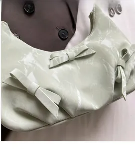 Detail of mint green marble texture leather handbag with three decorative bows