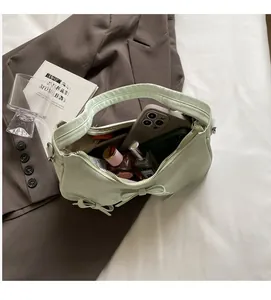 Spacious interior of a mint green handbag showing space for phone and perfume