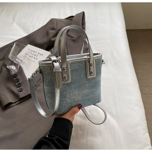 Close-up of blue denim bucket bag featuring sparkling rhinestones and silver handle detail