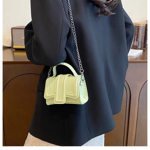 Detail shot of a pistachio green mini crossbody bag with crocodile embossed texture