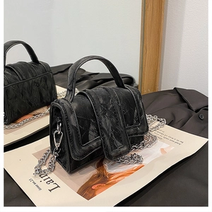 Detail of black marble texture mini square bag with silver chain strap and top handle