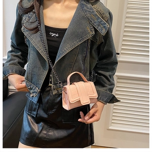 Close-up of pink mini crossbody bag featuring crocodile texture and chain strap