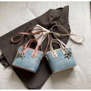 Detailed top view of mini denim tote bags with leather trim and balloon dog charms