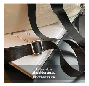 Detalle de la correa ajustable de nailon negro con hebilla metálica en una mochila blanca