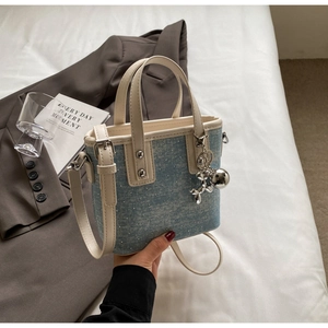 Close-up of blue denim mini bag with sparkling rhinestones and balloon rabbit charm