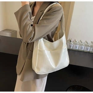 Détail du sac hobo blanc crème avec grain vertical brillant et poche latérale avant