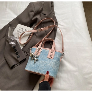 Detail of light blue denim tote with pink PU handles and silver balloon dog charm