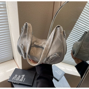 Detail of grey marble texture handbag with ribbon bow accent and half-moon silhouette