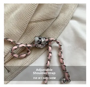 Detail of adjustable pink leather and silver chain strap with diamond pattern metal buckle