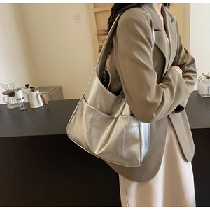 Gros plan du grand sac hobo argenté métallisé avec texture plissée et large bandoulière