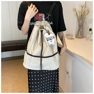 Detail eines beigen Canvas-Rucksacks mit Netztaschen und einem süßen Plüschwelpen