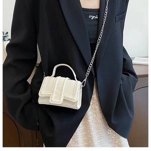 Detail of cream mini crossbody bag with marble texture and silver chain strap