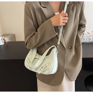 Detailed view of mint green crescent bag with bow accents and elegant leather texture