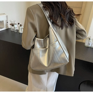 Vue détaillée d'un sac cabas argenté avec texture verticale et grande poche latérale pratique