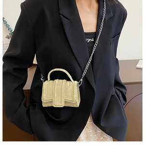 Detailed macro view of light green mini handbag with glossy wrinkled leather texture
