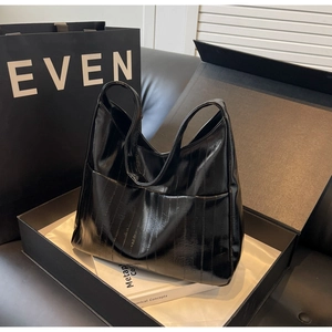 Détail de la texture en cuir verni noir motif crocodile et de la poche extérieure