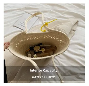 Vue détaillée de l'intérieur d'un grand sac cabas blanc tressé avec des cosmétiques