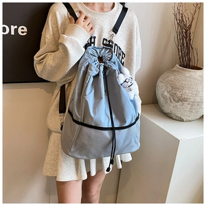 Nahaufnahme des hellblauen Nylon-Rucksacks mit grauem Mesh-Besatz und Plüsch-Hasenanhänger