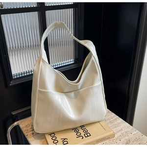 Gros plan du sac cabas ivoire en cuir texturé avec une large bandoulière élégante