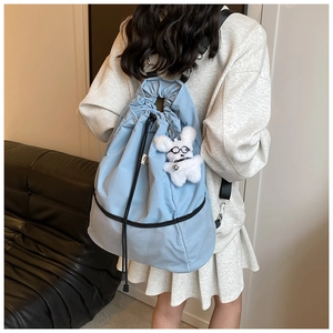 Detail eines hellblauen Nylon-Kordelzug-Rucksacks mit Netzteil und Plüschhund-Anhänger