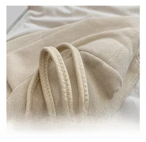 Gros plan sur la poignée épaisse et les détails du tissu tissé du sac cabas beige