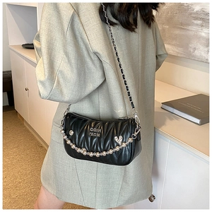 Detail of black quilted leather shoulder bag with silver beads and chain strap