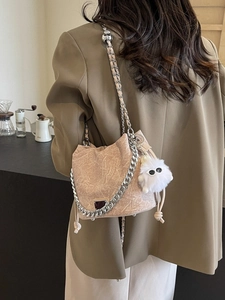 Chic beige textured bucket bag with silver chain and white plush monster charm