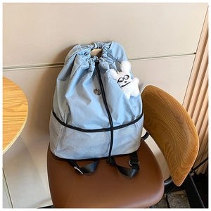 Detail von blauem Nylonrucksack mit Mesh-Boden und süßem weißen Hundeanhänger